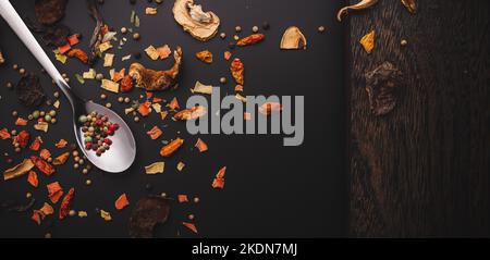 Nahaufnahme von getrockenen Gewürzen wie Chilipilzen und Pfeffer auf dunkler Oberfläche oder Tisch mit Variationen in der feinen Küche mit Kopierfläche Stockfoto