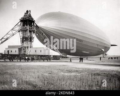 Die Hindenburg wird nach ihrer ersten transatlantischen Überfahrt in die USA in Lakehurst, NJ, vertäut. Das Logo der Olympischen Ringe ist auf der Seite des Luftschiffes zu sehen - Mai 9 1936 Stockfoto