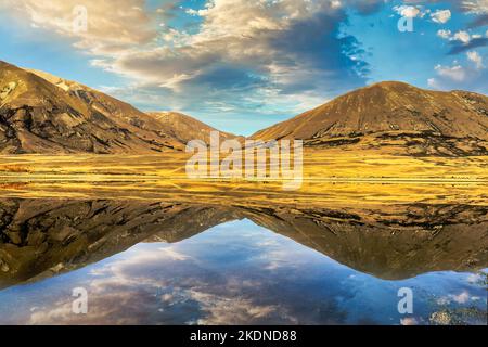 Atemberaubende, kristallklare Berg- und Himmelsreflexionen auf der ruhigen Wasseroberfläche des Lake Camp im Hochland der Ashburton Lakes Stockfoto