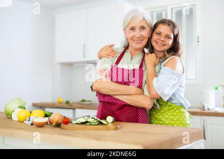 Porträt einer fröhlichen älteren Frau und ihrer Tochter in der Küche Stockfoto