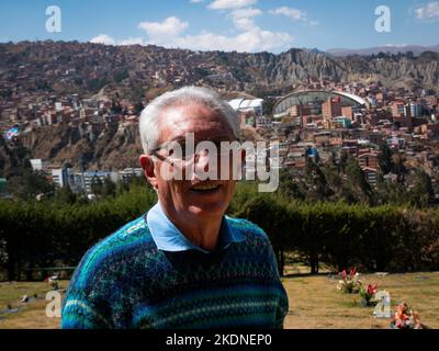 Porträt eines grauhaarigen Mannes mit Brille in einem Garten an einem sonnigen Tag Stockfoto