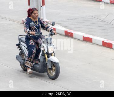 SAMUT PRAKAN, THAILAND, SEP 28 2022, Eine Frau in einem Kleid fährt ein Motorrad Stockfoto