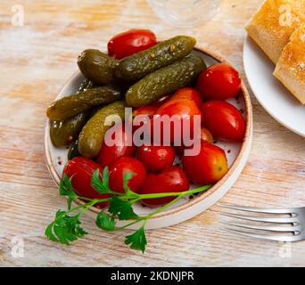 Portion eingelegte Tomaten und Gurken Stockfoto
