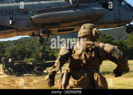 Ein US Marine Corps CH-53E Super Hengst hebt einen M777 Howitzer während einer Trainingsveranstaltung in Camp Hansen, Okinawa, Japan, am 3. November 2022. Das Training erhöhte die Fähigkeiten auf dem Schlachtfeld und die Kampfbereitschaft in allen Einheiten der Marine Air-Ground Task Force und erweiterte gleichzeitig die Fähigkeit für Kommandeure, Artillerieanlagen in kargem Gelände zu verlagern. (USA Marine Corps Foto von Lance CPL. Eduardo Delatorre) Stockfoto