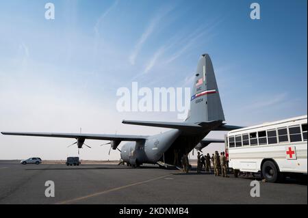 405. Expeditionary Aeromedical Evacuation Squadron und 386. Expeditionary Medical Squadron Airmen trainieren während einer Übung auf der Ali Al Salem Air Base, Kuwait, 31. Oktober 2022, wie Patienten sicher von einem Ambus zu einem C-130J Super Hercules transportiert werden können. Der Ambus ist ein umgewandelter Bus, der verwendet wird, um mehrere Patienten in einer bestimmten Situation auf eine höhere Betreuungsgruppe zu übertragen. (USA Foto der Luftwaffe von Staff Sgt. Dalton Williams) Stockfoto