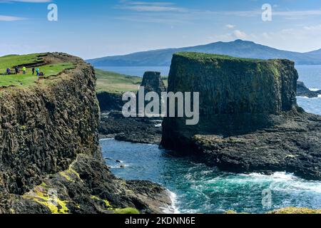 Die Seestapel von Dùn Beag und Dùn Mòr (rechts) auf der Insel Sanday, Schottland, Großbritannien, mit den Hügeln von Rum. Stockfoto