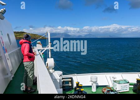 An Bord der Caledonischen MacBrayne Small Isles Fähre, der MV Lochnevis, verlässt die Isle of Rum, Schottland, Großbritannien. Die Berge von Skye in der Ferne. Stockfoto