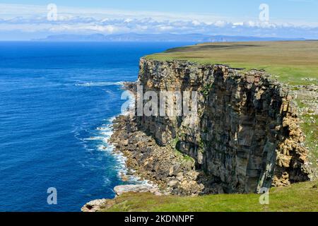 Klippen in der Nähe von Briga Head auf der westlichen Seite von Dunnet Head, Caithness, Schottland, Großbritannien. In der Ferne sind die Hügel von Hoy, Orkney. Stockfoto