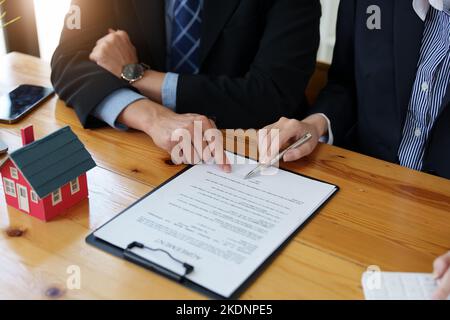 Garantien, Hypotheken, Unterzeichnung, Zinsen auf Darlehen, Immobilienmakler machen Vereinbarungen mit Kunden Häuser und Grundstücke zu kaufen und Vertrag zu unterzeichnen Stockfoto