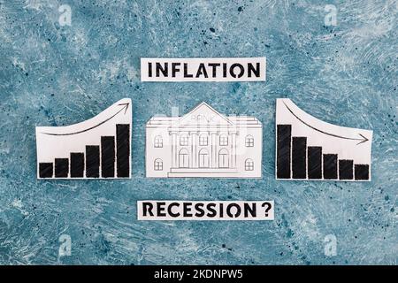 Texte zu Inflation und Rezession mit Bankensymbol in den Diagrammen mit Statistiken, die nach oben und nach unten gehen, Konzept der wirtschaftlichen Kämpfe nach der Pandemie Stockfoto