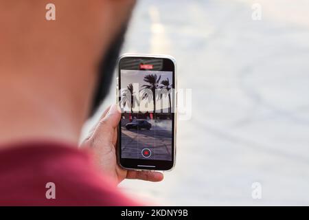 Misrata, Libyen. 07.. November 2022. Ein Zuschauer zeichnet das Autodrift-Ereignis mit seinem Handy auf. Junge Libyer, die gerne Autos fahren, lieben es zu treiben, aber sie übten es ohne Kontrollen und ohne ein geeignetes Feld dafür. Der Libysche Internationale Automechanic Carnival bietet ihnen jedoch die Möglichkeit, die berühmten Menschen zu treffen, die in diesem Sport treiben, und mit ihnen Unterricht und Erfahrungen zu erhalten. Kredit: SOPA Images Limited/Alamy Live Nachrichten Stockfoto