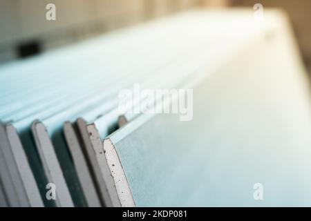 Viele feuchtigkeitsbeständige Trockenbauplatten auf einer Baustelle aus der Nähe. Universelles Material für die Verkleidung. Gefaltete Baumaterialien nach der Lieferung Stockfoto