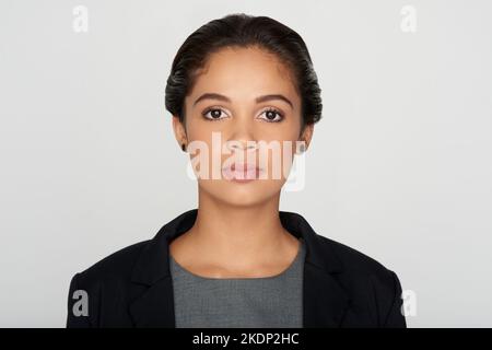 Es geht darum, selbstbewusst und entschlossen zu bleiben. Studioportrait einer selbstbewussten jungen Geschäftsfrau vor grauem Hintergrund. Stockfoto