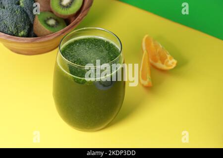Köstlicher frischer grüner Kiwi-Smoothie mit Orangensaft auf gelbem Hintergrund, Platz zum Kopieren Stockfoto