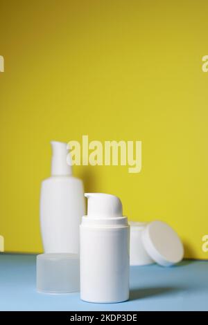 Modell aus weißem Glas mit Creme auf gelbem Hintergrund. Bereit für das Etikett, Platz für die Kopie Stockfoto