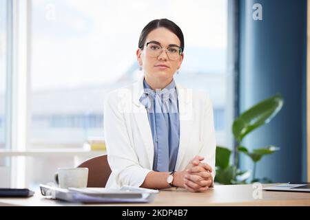 Porträt einer Ärztin, die in ihrem Krankenhausbüro mit Gesundheits-, Medizin- oder medizinischen Unterlagen arbeitet. Ernst, Frau und professioneller Chirurg sitzen Stockfoto