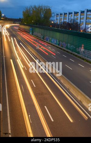 PRODUKTION - 07. November 2022, Sachsen-Anhalt, Magdeburg: Der abendliche Rushhour-Verkehr rollt über die Stadtautobahn der Landeshauptstadt Magdeburg. Aufgrund der langen Belichtung hinterlassen die Lichter der Fahrzeuge Streifen auf dem Bild. In Sachsen-Anhalt fahren die meisten Menschen nach Magdeburg. Dies wird durch neue Zahlen des Staatlichen Statistikamtes bestätigt. Demnach hatte die Landeshauptstadt 2021 mit knapp 18.000 arbeitenden Menschen die höchste Pendlerbilanz in Sachsen-Anhalt. Das bedeutet, dass mit rund 53.000 deutlich mehr Erwerbstätige in der Stadt zur Arbeit pendelten als p Stockfoto