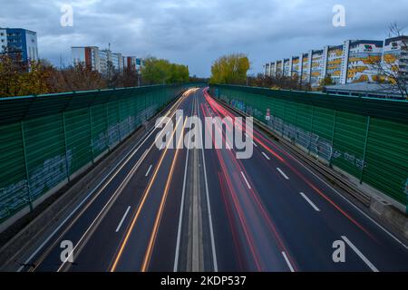 PRODUKTION - 07. November 2022, Sachsen-Anhalt, Magdeburg: Der abendliche Rushhour-Verkehr rollt über die Stadtautobahn der Landeshauptstadt Magdeburg. Aufgrund der langen Belichtung hinterlassen die Lichter der Fahrzeuge Streifen auf dem Bild. In Sachsen-Anhalt fahren die meisten Menschen nach Magdeburg. Dies wird durch neue Zahlen des Staatlichen Statistikamtes bestätigt. Demnach hatte die Landeshauptstadt 2021 mit knapp 18.000 arbeitenden Menschen die höchste Pendlerbilanz in Sachsen-Anhalt. Das bedeutet, dass mit rund 53.000 deutlich mehr Erwerbstätige in der Stadt zur Arbeit pendelten als p Stockfoto