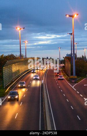 PRODUKTION - 07. November 2022, Sachsen-Anhalt, Magdeburg: Der abendliche Rushhour-Verkehr auf der Stadtautobahn der Landeshauptstadt Magdeburg. Aufgrund der langen Belichtung hinterlassen die Lichter der Fahrzeuge Streifen auf dem Bild. In Sachsen-Anhalt fahren die meisten Menschen nach Magdeburg. Dies wird durch neue Zahlen des Staatlichen Statistikamtes bestätigt. Demnach hatte die Landeshauptstadt 2021 mit knapp 18.000 arbeitenden Menschen die höchste Pendlerbilanz in Sachsen-Anhalt. Das bedeutet, dass mit rund 53.000 deutlich mehr Beschäftigte in der Stadt zur Arbeit pendelten als Menschen Stockfoto