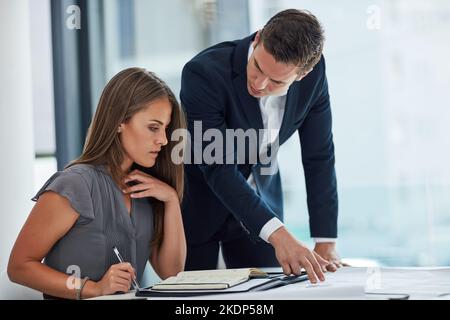 Hart arbeiten, um einen narrensicheren Plan zu entwickeln. Zwei Geschäftsleute, die im Büro eine Diskussion führen. Stockfoto