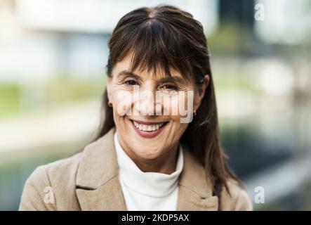 Ältere Frau, Gesicht und Lächeln für Vision, Ehrgeiz oder beruflichen Erfolg in Glück für die Arbeit in der Stadt. Porträt einer glücklichen älteren Frau lächelnd Stockfoto