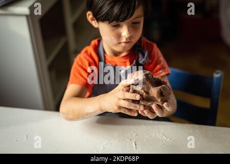 Nahaufnahme der Kinderhände, die den Teig kneten Stockfoto