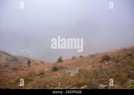 Srinagar, Indien. 07.. November 2022. Ein Mann geht den Hügel während eines nebligen Wetters am Stadtrand von Srinagar hinauf. Regen setzte sich fort, die Ebenen zu schlagen, während obere Reichweiten Schneefall erhielten, da der Wettermann bis November 11 mehr nasses Wetter in Jammu und Kaschmir vorhersagte. Kredit: SOPA Images Limited/Alamy Live Nachrichten Stockfoto