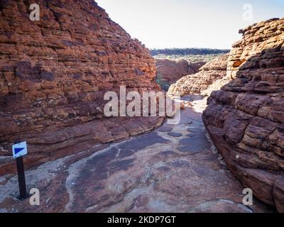 Wandermarkierung auf einem schmalen Abschnitt des Rim Walk zwischen Sandsteinkuppeln, Kings Canyon, Watarrka National Park, Northern Territory, Australien Stockfoto