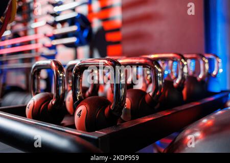 Kettlebells in verschiedenen Farben. Sportgeräte im Fitnessstudio. kettlebell für das Fitnesstraining. Ein Schuss Gewichte Reihen sich in einer Reihe im Fitnessstudio an. Stockfoto