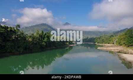 Malerischer Panoramablick auf das Tal des Subansiri-Flusses mit Berghintergrund und niedrigen Morgenwolken in Daporijo, Arunachal Pradesh, Indien Stockfoto