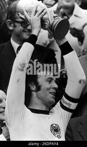 Datei Foto vom 09-07-1974 von Kapitän Franz Beckenbauer hält die WM-Trophäe, nachdem er Holland 2-1 im Finale in München besiegt hatte. „Der Kaiser“, bekannt für seine Positionierung und Verteilung, spielte in drei World Cups - einschließlich der Endniederlage 1966 gegen England und in der Halbfinalniederlage gegen Italien vier Jahre später, Arm in einer Schlinge mit einem gebrochenen Schlüsselbein. Schließlich bekam Beckenbauer die Trophäe in die Hände, als die Bundesrepublik 1974 die WM auf heimisch-deutschem Boden gewann. Ausgabedatum: Dienstag, 8. November 2022. Stockfoto