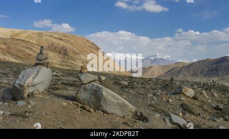 Landschaftlich reizvoller Blick auf schneebedeckte Berge mit cairns im Vordergrund am hochgelegenen Khargusch-Pass in Gorno-Badakshan, Tajikistan Pamir Stockfoto