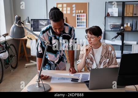 Porträt zweier kreativer junger Menschen, die bei der Zusammenarbeit an einem Interior Design-Projekt die Farbpalette wählen Stockfoto