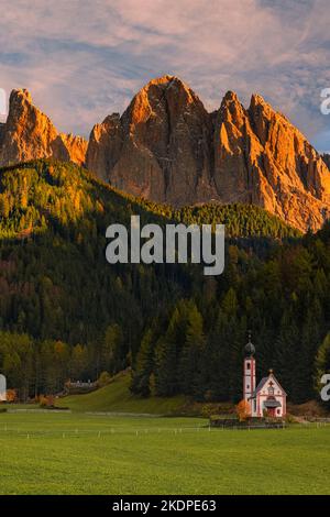 Sonnenuntergang an der berühmten Kirche von San Giovanni in Ranui (Sankt Johann) vor den Geisler- oder Geisler-Dolomiten-Gipfeln in Santa Maddalena (Sankt Stockfoto