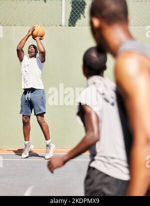 Fitness-, Basketball- und Basketballspieler schießen in einem Trainingsspiel, Sportübungen oder trainieren im Freien. Wellness, Fokus und gesunde Männer genießen Stockfoto