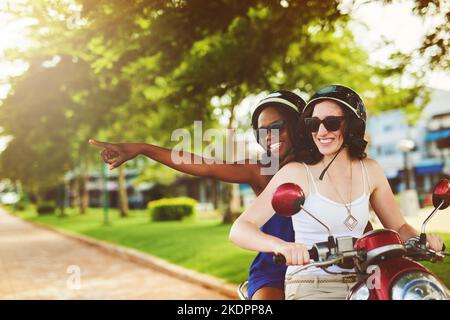 Abenteuer auf dem Rücken eines Fahrrads. Zwei Freunde genießen eine Fahrt auf einem Roller zusammen. Stockfoto