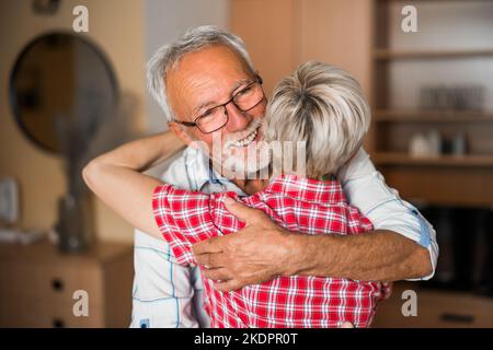 Porträt eines glücklichen älteren Ehepaars zu Hause. Seniorenumarmung. Stockfoto