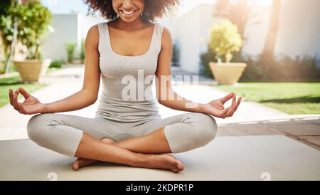 Eine sportliche junge Frau, die im Freien Yoga praktiziert. Stockfoto