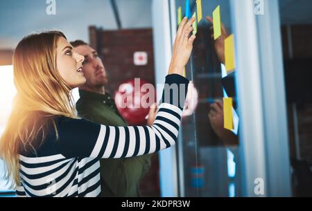 Verwenden der besten Brainstorming-Techniken zur Steigerung der Produktivität. Kollegen, die eine Brainstorming-Sitzung mit Haftnotizen bei der Arbeit haben. Stockfoto