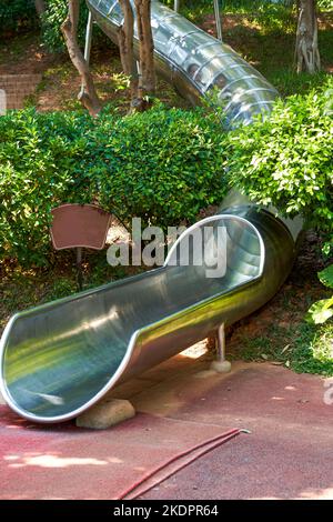 Zylinderrutsche aus Edelstahl auf dem Spielplatz im Park Stockfoto