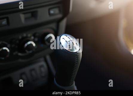 Nahaufnahme eines Schalthebels. Schaltgetriebe. Details zur Fahrzeuginnenausstattung. Autogetriebe. Sanftes Licht. Stockfoto