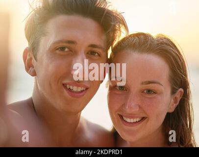 Nur wir beide. Porträt eines jungen Paares, das am Strand ein Selfie gemacht hat. Stockfoto