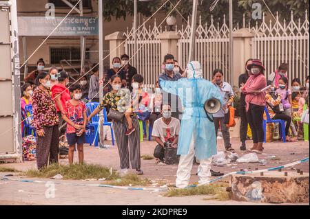 Ein EMT leitet eine Massenteststelle. Eine kambodschanische Mutter und ihre zwei kleinen Jungen haben alle positiv auf das Virus getestet. Phnom Penh, Kambodscha. © Kraig Lieb Stockfoto