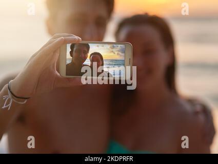Ein weiterer Sommer-Schnappschuss. Ein junges Paar, das ein Selfie am Strand gemacht hat. Stockfoto