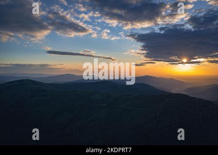 Sonnenuntergang über den schlesischen Beskiden-Bergen in der Stadt Szczyrk, Kreis Bielsko, Woiwodschaft Schlesien in Südpolen Stockfoto