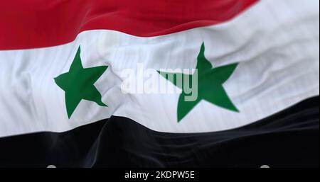 Nahaufnahme der im Wind wehenden syrischen Nationalflagge. Die Arabische Republik Syrien ist ein westasiatisches Land. Texturierter Hintergrund aus Stoff. Selektiv Stockfoto