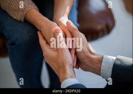 Nahaufnahme der Hände des Mannes, der die Hände der Womanen hält Stockfoto
