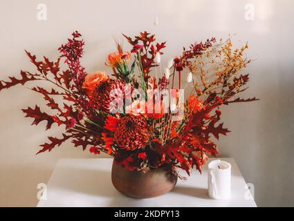 Dunkelpflaumenviolette Chrysanthemen und rosafarbene Rosenblumen als Hintergrund. Stockfoto