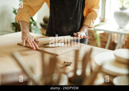 Nahaufnahme einer jungen Frau, die in einem gemütlichen Töpferstudio handgemachte Keramik anfertigte, Kopierraum Stockfoto