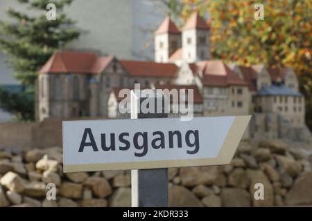 Wernigerode, Deutschland. 08.. November 2022. Vor dem Vorbild der Stiftskirche Quedlinburg steht im Miniaturpark ein Schild mit der Aufschrift 'Ausweg'. Im Miniaturpark endete am 06. November die Besuchersaison. Die Modelle zahlreicher Harzer Sehenswürdigkeiten werden in den kommenden Tagen gelagert. Bis zur Eröffnung der Saison im nächsten Jahr werden die durch das Wetter verursachten Schäden repariert. Im Laufe des Jahres konnten mehr als 130000 Besucher im Bürger- und Miniaturpark begrüßt werden. Quelle: Matthias Bein/dpa/Alamy Live News Stockfoto